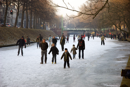 900014 Afbeelding van schaatsers op de bevroren Stadsbuitengracht te Utrecht, met op de achtergrond de Bartholomeïbrug.